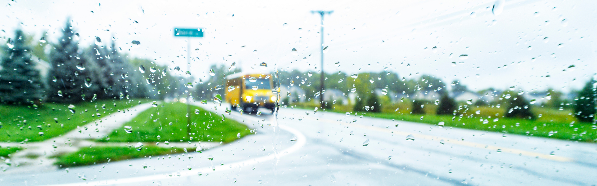 school bus on wet road through raindrops