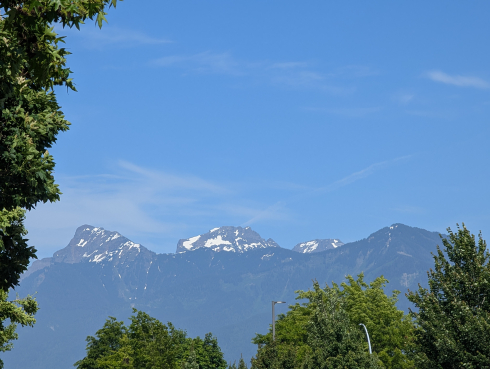 A view of three mountain tops underneath the blue sky.