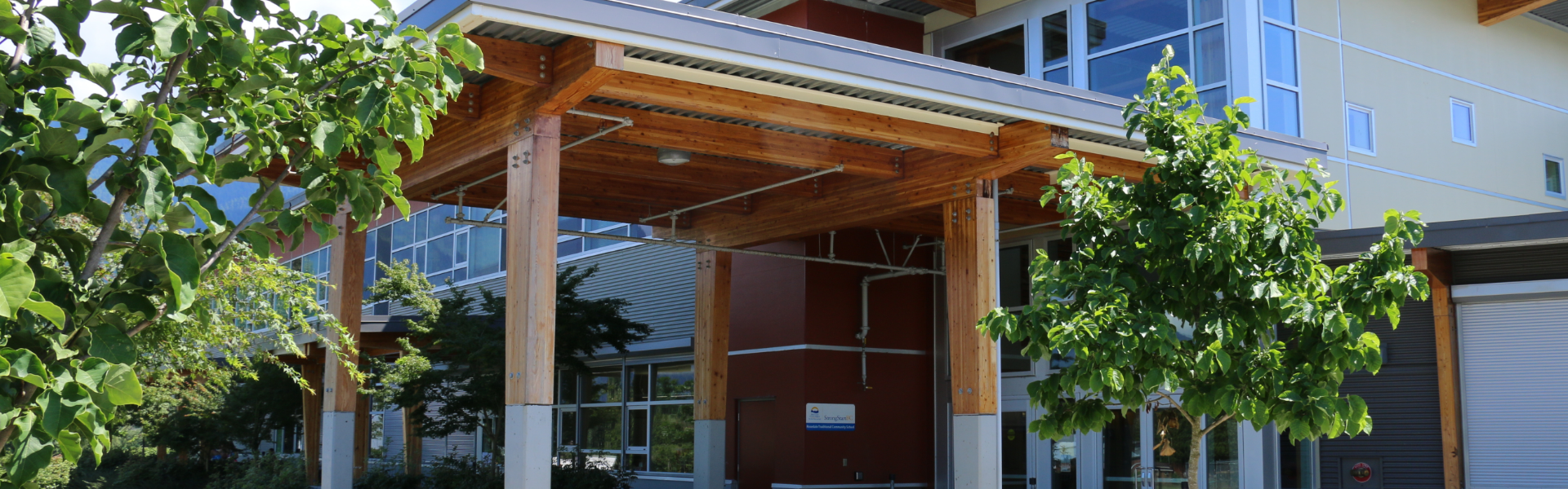 A school entrance with leafy trees nearby
