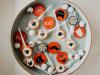 A white bowl full of orange, black and white Halloween candy. 