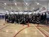 A group of youth pose in high school gym. 