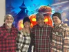 Four people are dressed in plaid shirts and toques for Halloween. 